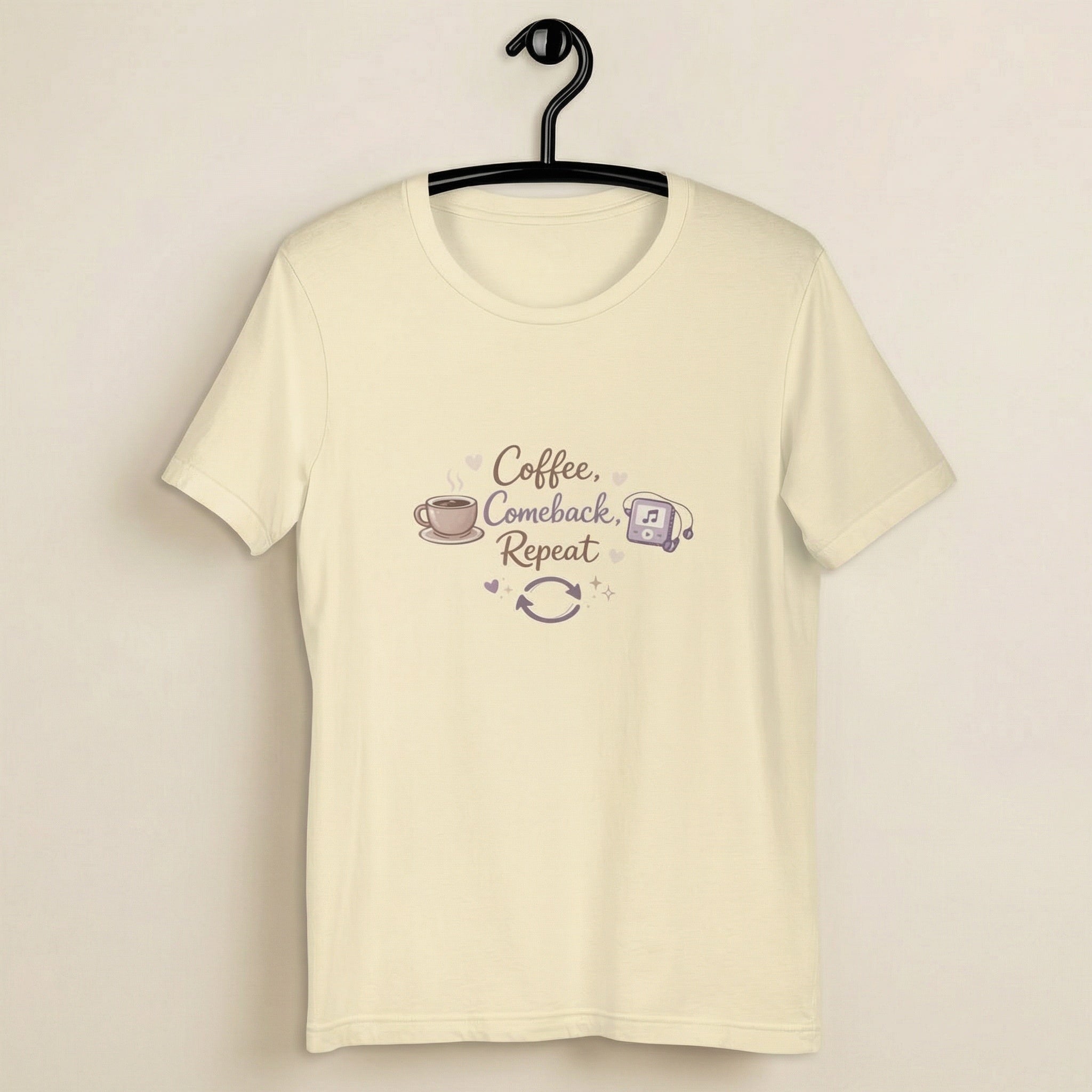 Beige t-shirt with 'Coffee, Comeback, Repeat' text and graphics on a hanger against a beige background