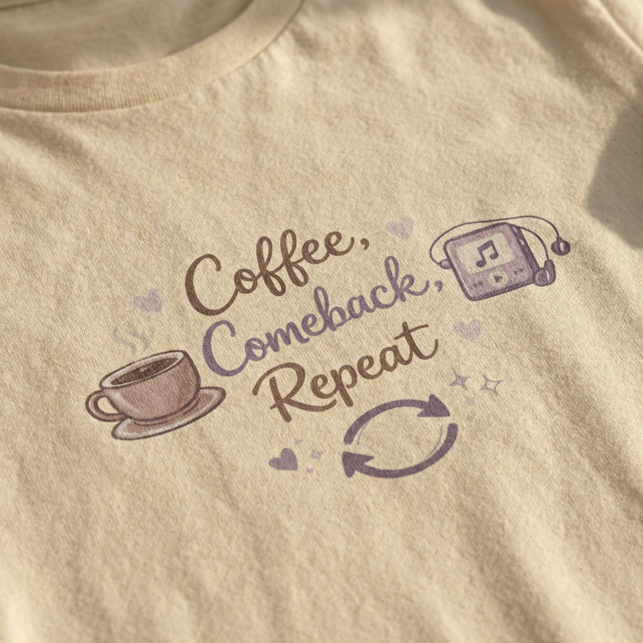 Beige t-shirt with 'Coffee, Comeback, Repeat' text and graphics on a plain background